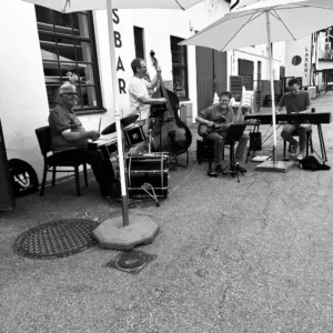 Sörens Jazzband uppträder live utomhus under vita parasoll på Håfveruds Brasseries uteservering vid kanalkanten.